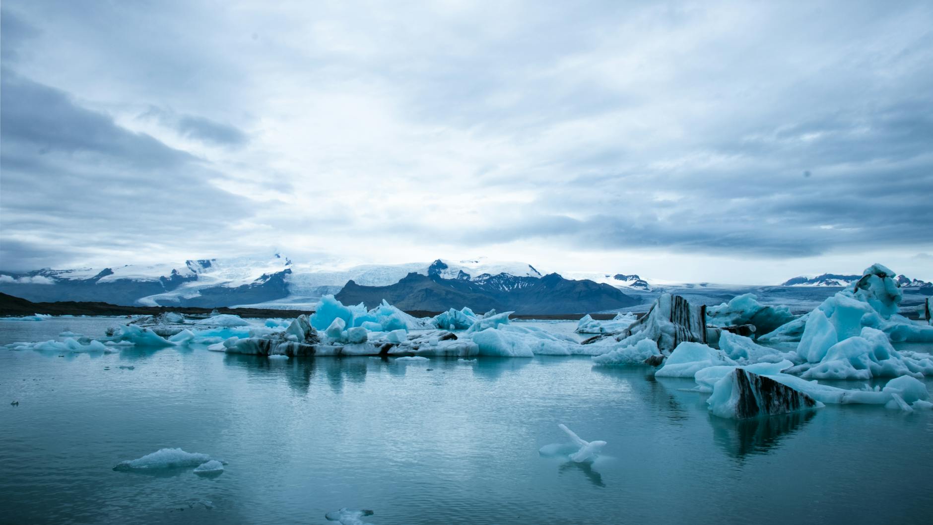 scenic view of snow capped mountains under cloudy sky
